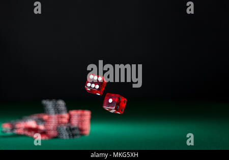 tumbling dice showing various numbers.  Craps, casino chips action and room in frame for copy space Stock Photo
