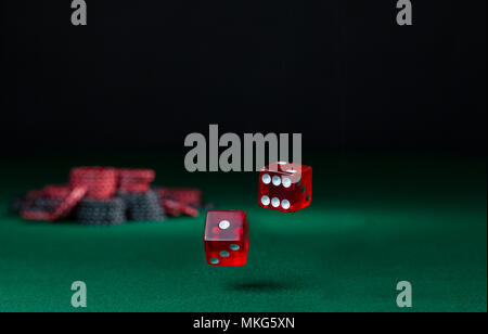 tumbling dice showing various numbers.  Craps, casino chips action and room in frame for copy space Stock Photo