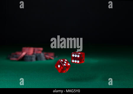 tumbling dice showing various numbers.  Craps, casino chips action and room in frame for copy space Stock Photo