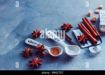 https://l450v.alamy.com/450v/mkg7d7/porcelain-measuring-spoons-and-metal-graters-on-a-blue-concrete-background-cooking-utensils-from-above-with-copy-space-baking-tools-and-ingredients-concept-mkg7d7.jpg