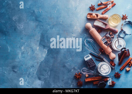 Making pastry concept with baking tools and ingredients on a modern  concrete background with copy space. Wooden scoops, whisks, cookie cutters,  muffin tin, sugar, flour, anise stars from above Stock Photo 