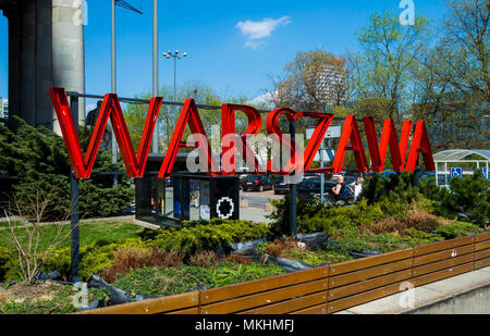 Metal red sign with the name of the Polish city Warsaw or Warszawa. Letters  in the center of the city surrounded by beautiful plants Stock Photo - Alamy