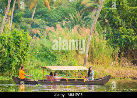 ALLEPPEEY - KERALA -INDIA. 26 JAN 2018. Some tourists are on a canoe sailing on the lush and green backwaters in Alleppey during the sunset, Kerala. Stock Photo