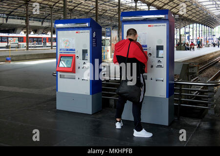 Young man purchasing tickets at the train station in Zurich, Switzerland, Europe Stock Photo