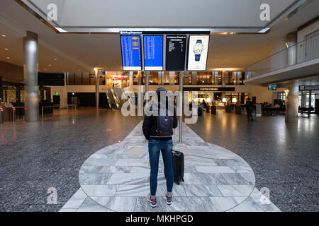 Female traveler walking through Zurich Airport with a rolling suitcase, Zurich, Switzerland, Europe Stock Photo