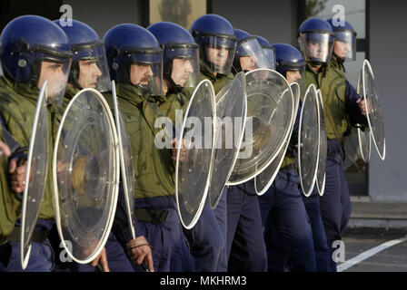 Riot police officers lined up with protective headgear and shields Stock Photo