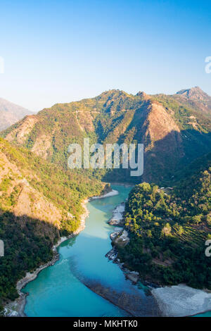 Wonderful green peaks of some mountains with the Ganges river flowing between them in Rishikesh, India Stock Photo