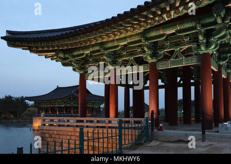 An illuminated colorfully-decorated pavilion at the Anapji (Wolji) Pond at dusk, part of the Silla Donggung Palace complex in Gyeongju, South Korea. Stock Photo