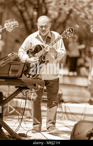 DIMITROVGRAD, BULGARIA - APRIL 30, 2018: Jazz guitar player focuses on performing solo at street concert event dedicated to International World Jazz D Stock Photo