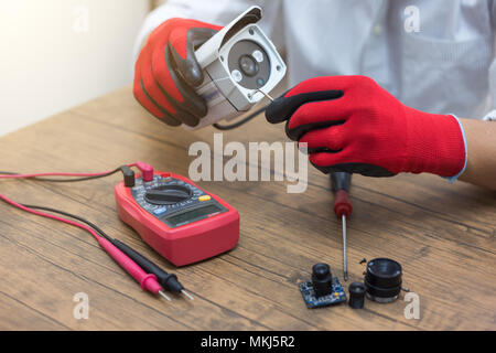 technician repairs CCTV camera on the table. Stock Photo