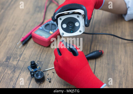 technician repairs CCTV camera on the table. Stock Photo