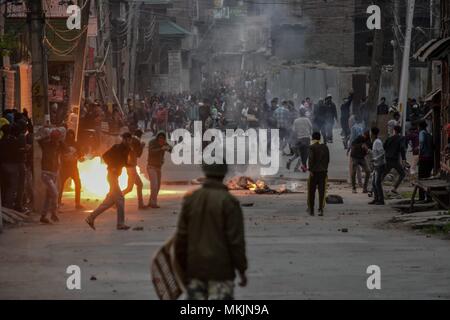 Srinagar, Kashmir. 8th May 2018. A tear gas shell explodes near Kashmiri protesters during clashes in Srinagar, Kashmir. Fierce clashes broke out between government forces and Kashmiri protesters in Srinagar on Tuesday as the valley continued to remain tense over the killing of 11 people including 5 militants and 6 civilians in Kashmir. Police used tear smoke shells and shot gun pellets to disperse hundreds of demonstrators who hurled rocks and chanted anti-and pro-freedom slogans. Credit: SOPA Images Limited/Alamy Live News Stock Photo