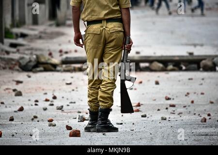 Srinagar, Kashmir. 8th May 2018. An policeman stands still during clashes in Srinagar, Kashmir. Fierce clashes broke out between government forces and Kashmiri protesters in Srinagar on Tuesday as the valley continued to remain tense over the killing of 11 people including 5 militants and 6 civilians in Kashmir. Police used tear smoke shells and shot gun pellets to disperse hundreds of demonstrators who hurled rocks and chanted anti-and pro-freedom slogans. Credit: SOPA Images Limited/Alamy Live News Stock Photo