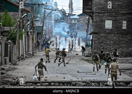 May 8, 2018 - Srinagar, J&K, India - Indian government forces chase Kashmiri protesters during clashes in Srinagar, Indian administered Kashmir. Fierce clashes broke out between government forces and Kashmiri protesters in Srinagar on Tuesday as the valley continued to remain tense over the killing of 11 people including 5 militants and 6 civilians in Indian administered Kashmir. Police used tear smoke shells and shot gun pellets to disperse hundreds of demonstrators who hurled rocks and chanted anti-Indian and pro-freedom slogans. Credit: Saqib Majeed/SOPA Images/ZUMA Wire/Alamy Live News Stock Photo