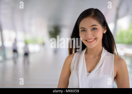 Young beautiful Asian businesswoman hanging out at the footbridg Stock Photo