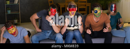 International football fans watching the game on tv Stock Photo