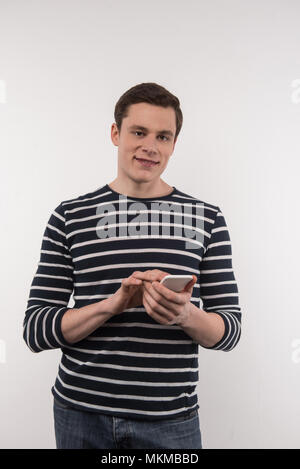 Joyful pleasant man using his smartphone Stock Photo