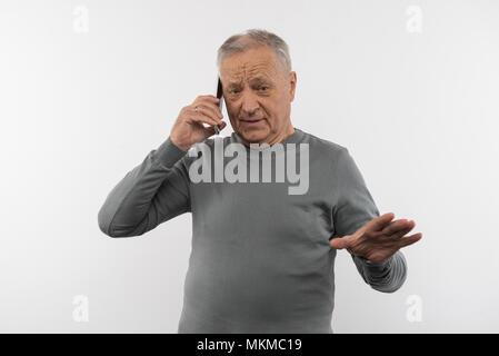 Pleasant elderly man having a phone conversation Stock Photo