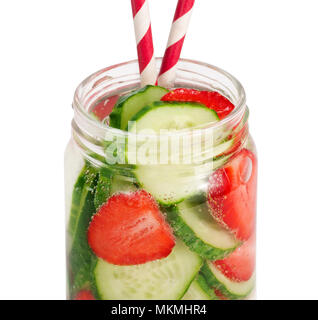 Strawberries and cucumbers swim in the sparkling water. Homemade lemonade made from strawberry and cucumber. Fruit slices in water with air bubbles. Stock Photo