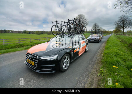 Team support cars driving in convoy, carrying bikes on roof racks during Tour de Yorkshire 2018 - country lane, Ilkley, North Yorkshire, England, UK. Stock Photo