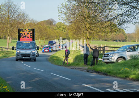 Spectators wave at official vehicle marking end of Tour de Yorkshire 2018  race on scenic, country lane - Ilkley, North Yorkshire, England, UK. Stock Photo