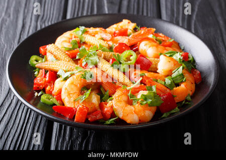 Freshly prepared Mexican prawns with sweet peppers, chili, garlic, corn cobs and herbs close-up on a plate. horizontal Stock Photo