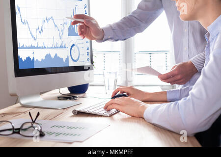 Traders discussing trading strategy for better profit and return on investment (ROI) by analyzing stock market and foreign exchange (forex) charts on  Stock Photo