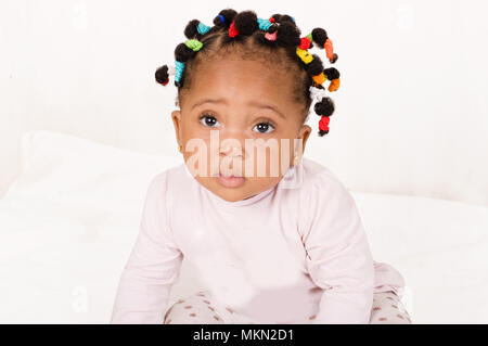 Portrait of a baby girl inocente laying the camera on white background. Stock Photo