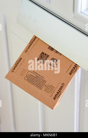Amazon online shopping home delivery parcel in a household letter box  Photograph taken by Simon Dack Stock Photo
