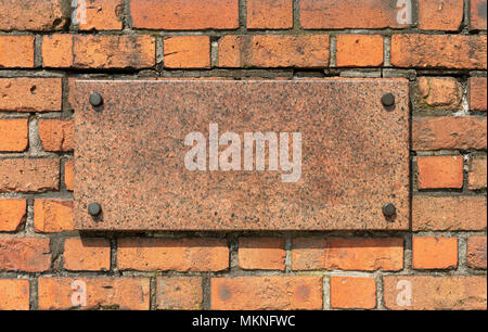 Granite board with metal pins on an old brick wall Stock Photo