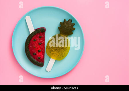 Pineapple and watermelon popsicles on pink background. Top view. Copyspace Stock Photo