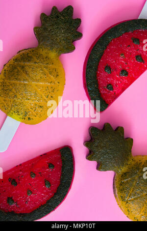Pineapple and watermelon popsicles on pink background. Top view Stock Photo