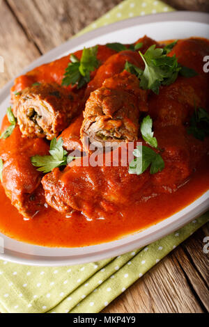 Italian meat roll braciole stuffed with parsley and cheese in tomato sauce close-up on a plate. vertical Stock Photo