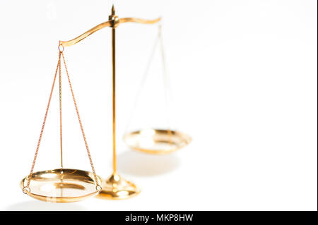 Close up of gold brass balance scale, Sign of justice isolated on white background Stock Photo