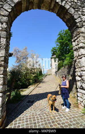 Rijeka, Croatia. Trsat castle.  It is thought that the castle lies at the exact spot of an ancient Illyrian and Roman fortress. A woman tourist with a Corso dog at the entrance of Trsat castle. Stock Photo