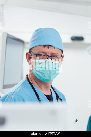 Anesthetist watching patient sleeping in operation room Stock Photo