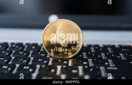 Gold Ethereum coin on a laptop. Ethereum crypto currency on a laptop black keyboard. Digital money and virtual cryptocurrency concept. Investment. Bussiness, commercial. Profit from mining. Stock Photo