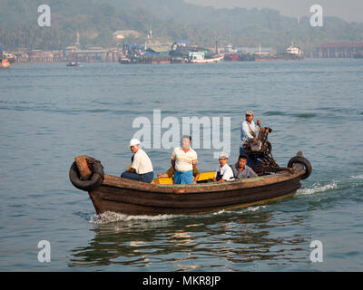 Small, wooden ferry, arriving in Myeik, formerly Mergui, the largest city in the Tanintharyi Region of Myanmar, with passengers from one of the nearby Stock Photo