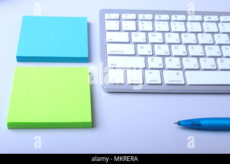 Office desk with keyboard and stikers, papers. Stock Photo