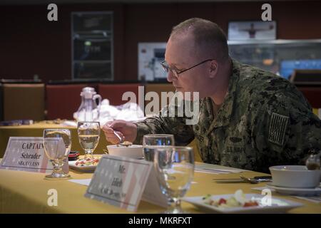 180505-N-EH218-0022 BREMERTON, Wash. (May 5, 2018) Capt. Alan Schrader, commanding officer, Naval Base Kitsap, samples an entry during the 26th Annual Armed Forces Culinary Arts Competition, May 5, 2018. Each year, service members from Naval Base Kitsap, Joint Base Lewis-McChord, Naval Station Everett, Naval Air Station Whidbey Island and other commands throughout the Pacific Northwest come together to compete in a battle of culinary ability for the title of 'Iron Chef. ' (U.S. Navy photo by Mass Communication Specialist 2nd Class Ryan J. Batchelder/Released). () Stock Photo