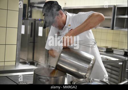 U.S. Army Spc, May 3, 2018. Arthur Hinojosa, a culinary specialist with Fury Battery, 4th Battalion, 319th Airborne Field Artillery Regiment, 173rd Airborne Brigade, prepares a meal at the Tower Barracks Dining Facility, Grafenwoehr, Germany, May 3, 2018. (U.S. Army photo by Gertrud Zach). () Stock Photo