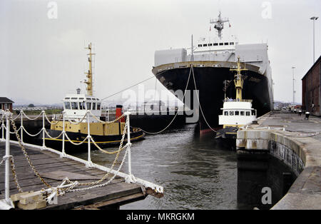 Bulk car carrying ship Venus Diamond leaving Newport Docks spring 1992 Wales UK Escorted by a pair of tug boats, Welsh coastal port. British Coast Docks lock Stock Photo