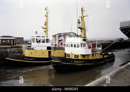 A pair of tug boats, pulling Bulk car carrying ship, Venus Diamond through the locks at Newport Docks spring 1992. Wales UK. Welsh coastal port Stock Photo