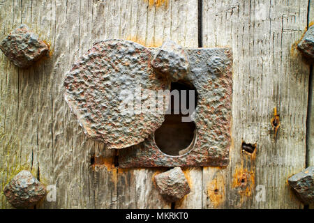 old iron lock in iron studded old oak door to the lock up Lacock village wiltshire england uk Stock Photo