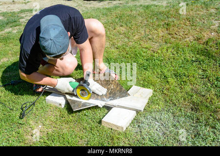 The plasterer master cuts the marble tile round the ceramic disc 2018 Stock Photo