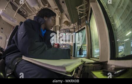 180507-N-ZK016-0010 U.S. 5TH FLEET AREA OF OPERATIONS (May 7, 2018) Aviation Boatswain's Mate (Handling) 3rd Class Charmeise Raeford, from Washington, D.C. stands watch during aircraft movement in the hangar bay aboard the Wasp-class amphibious assault ship USS Iwo Jima (LHD 7), May 7, 2018, May 7, 2018. Iwo Jima, homeported in Mayport, Fla. is on deployment to the U.S. 5th Fleet area of operations in support of maritime security operations to reassure allies and partners, and preserve the freedom of navigation and the free flow of commerce in the region. (U.S. Navy photo by Mass Communication Stock Photo