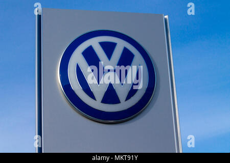 Volkswagen logo a german car manufacture company logo or badge standing out against a bright blue evening sky. Stock Photo