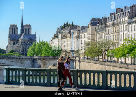 Young caucasian girls walking on a bridge, seine river, paris, france Stock Photo