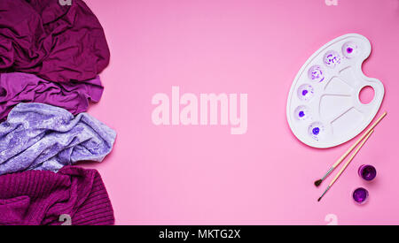 Violet and purple woman clothes and palette on pink background Stock Photo
