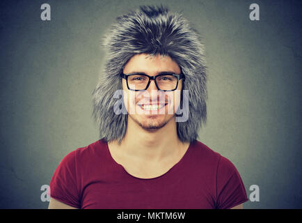 Handsome smiling man in casual t-shirt and eyeglasses wearing warm winter hat smiling at camera. Stock Photo